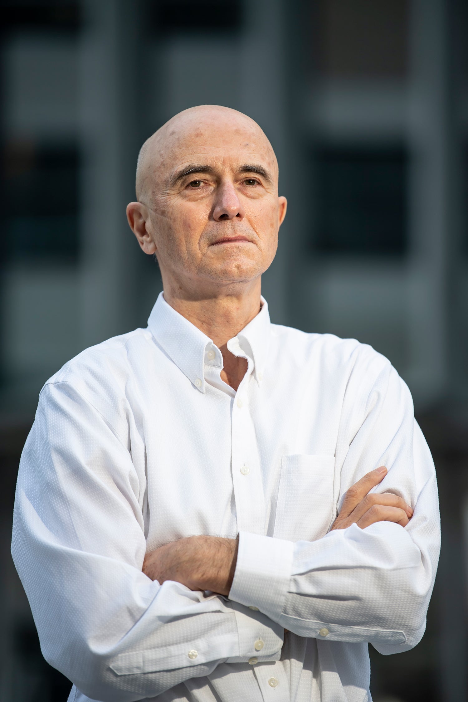 white man wearing white button-down shirt with arms crossed