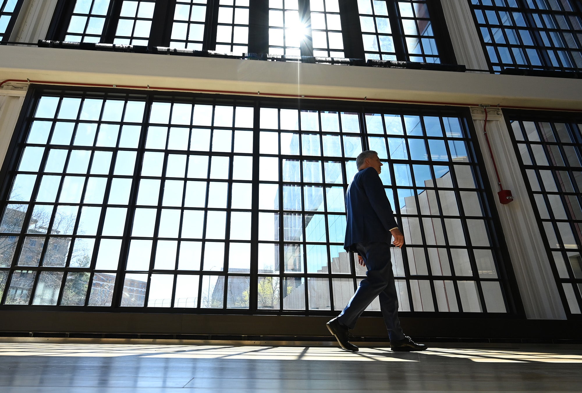 Gallagher walks past a wall of windows