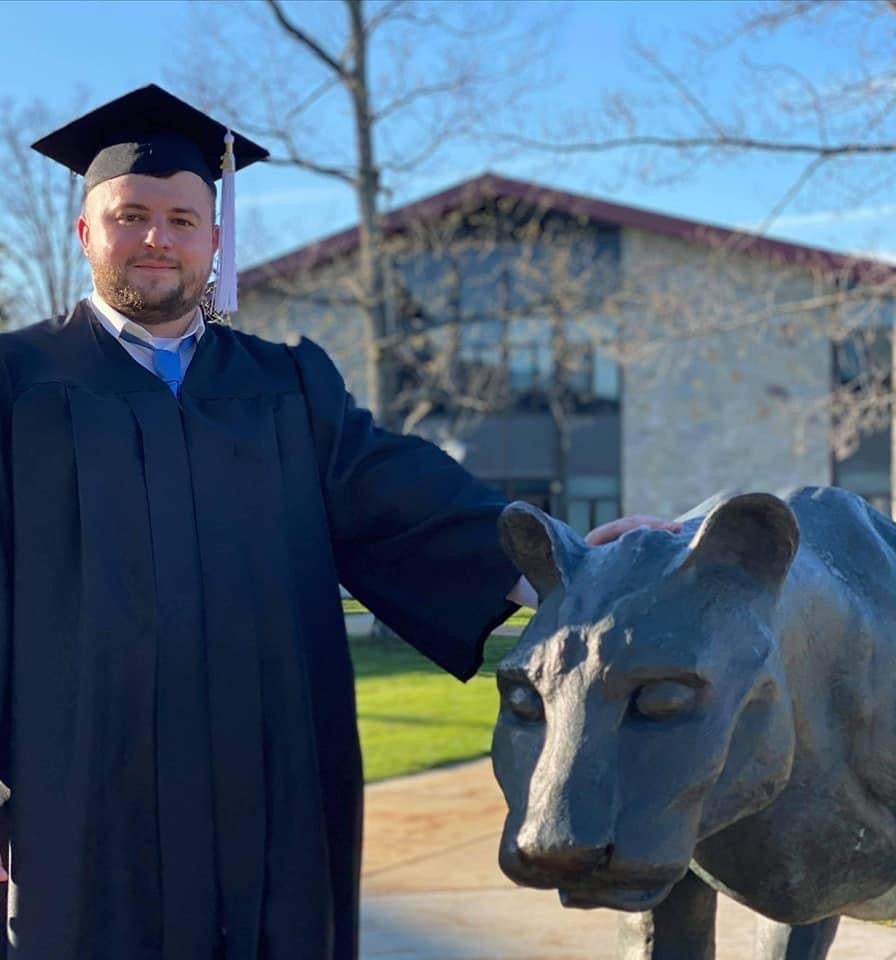 AAron Capouellez poses with a Mountain Cat statue at Pitt-Johnstown