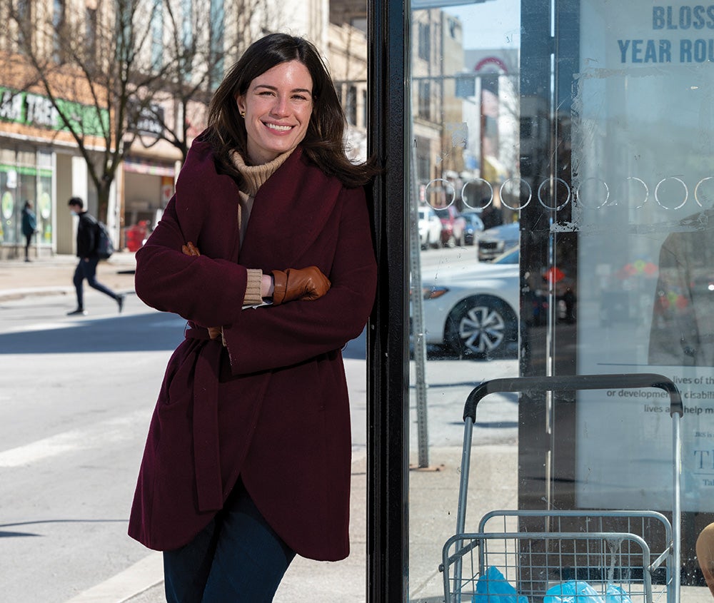 Schwanke in a black coat at a bus stop