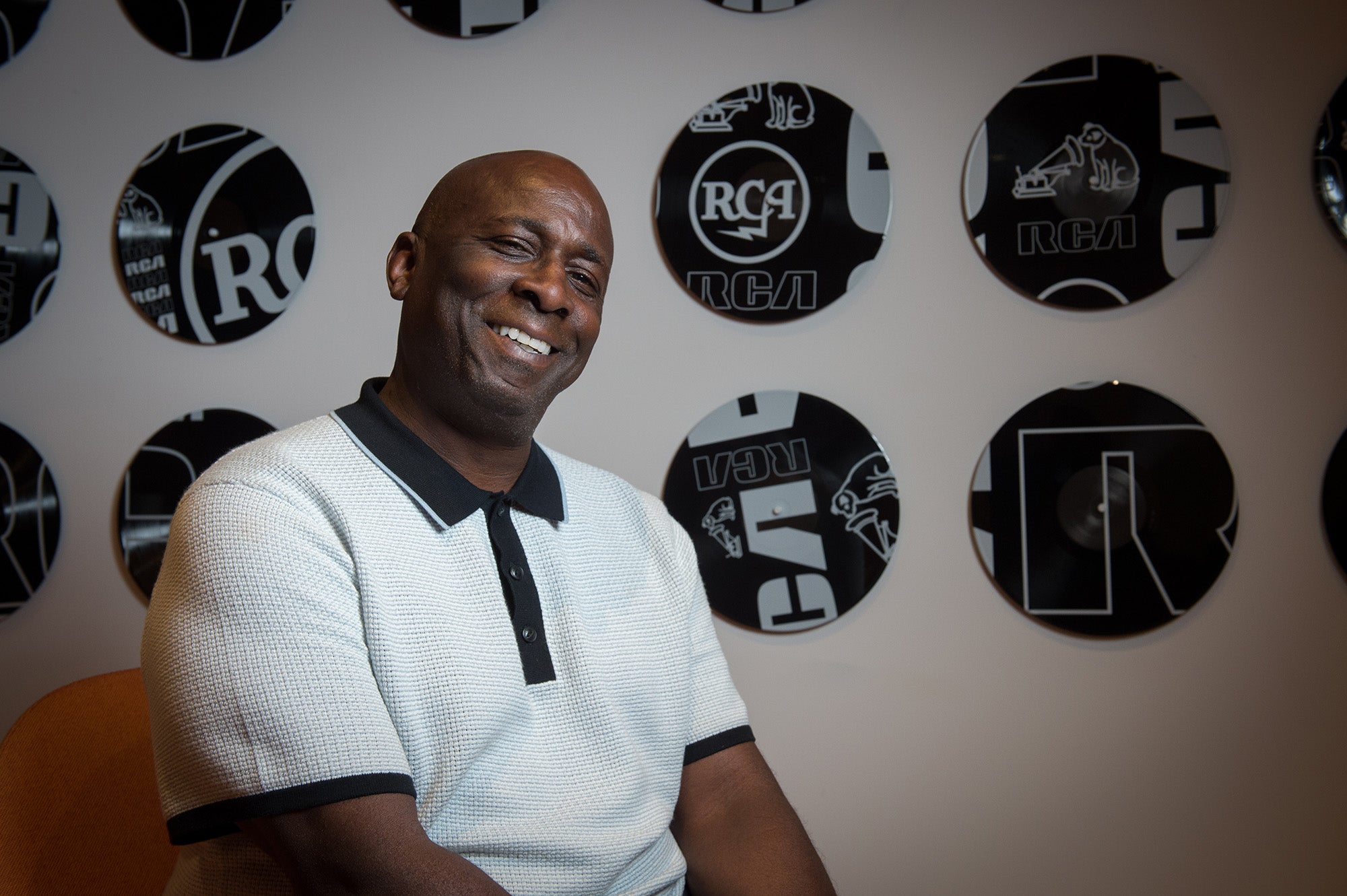 Bivins sits in front of a wall of black records