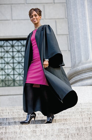 Judge Simpson in her black judicial robe in front of a courthouse.