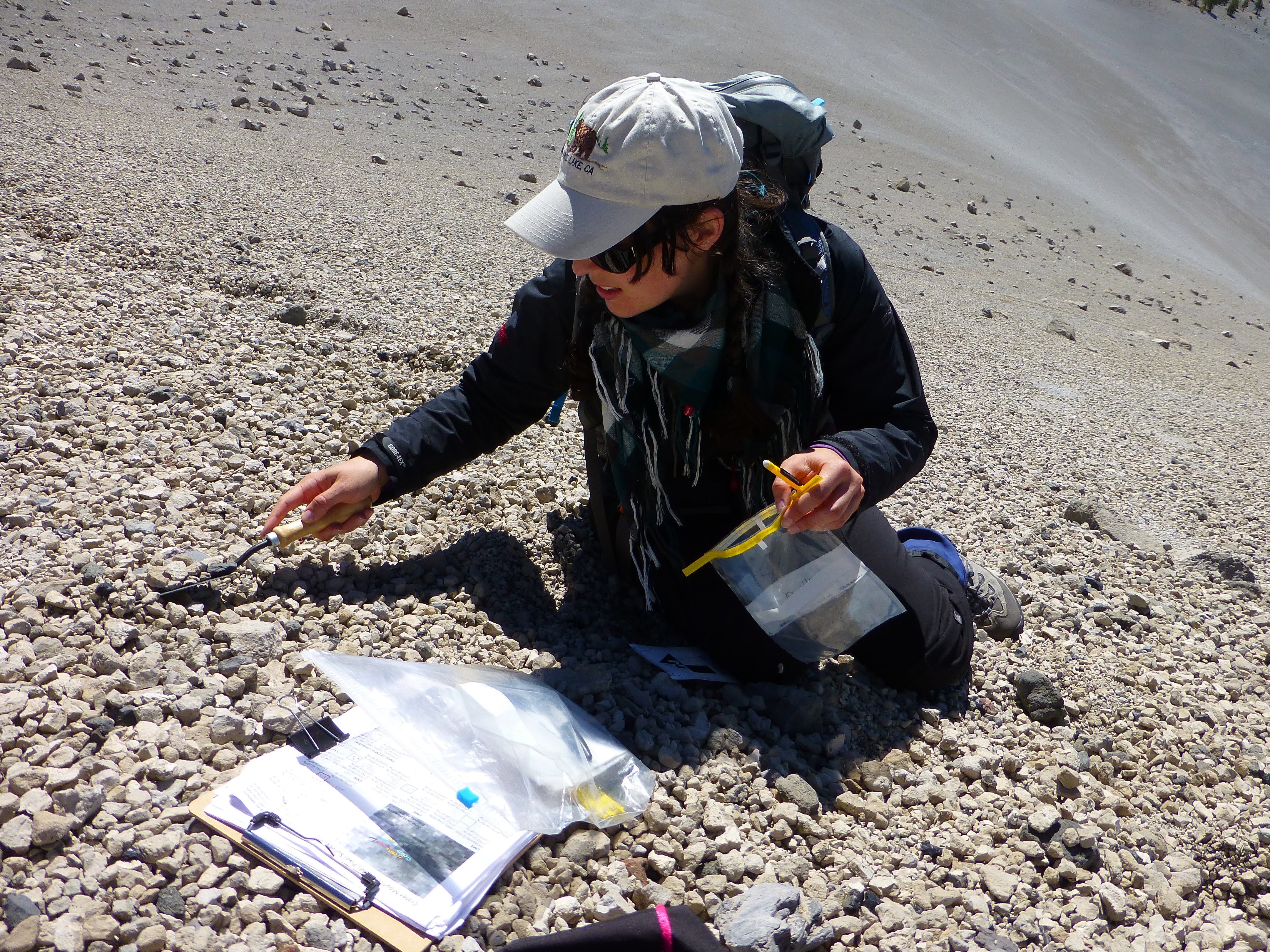 Janine Krippner collects sediment samples at volcano site.