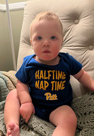 A baby wearing a Pitt branded onesie