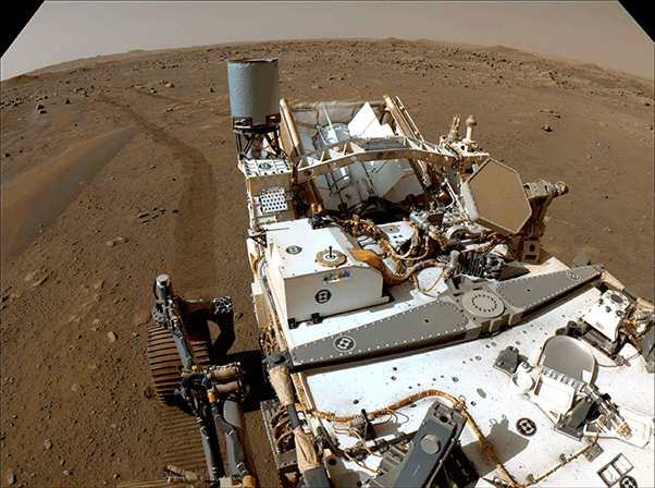 Perseverance rover, a white with metallic details, and tire tracks appear on brown Mars surface