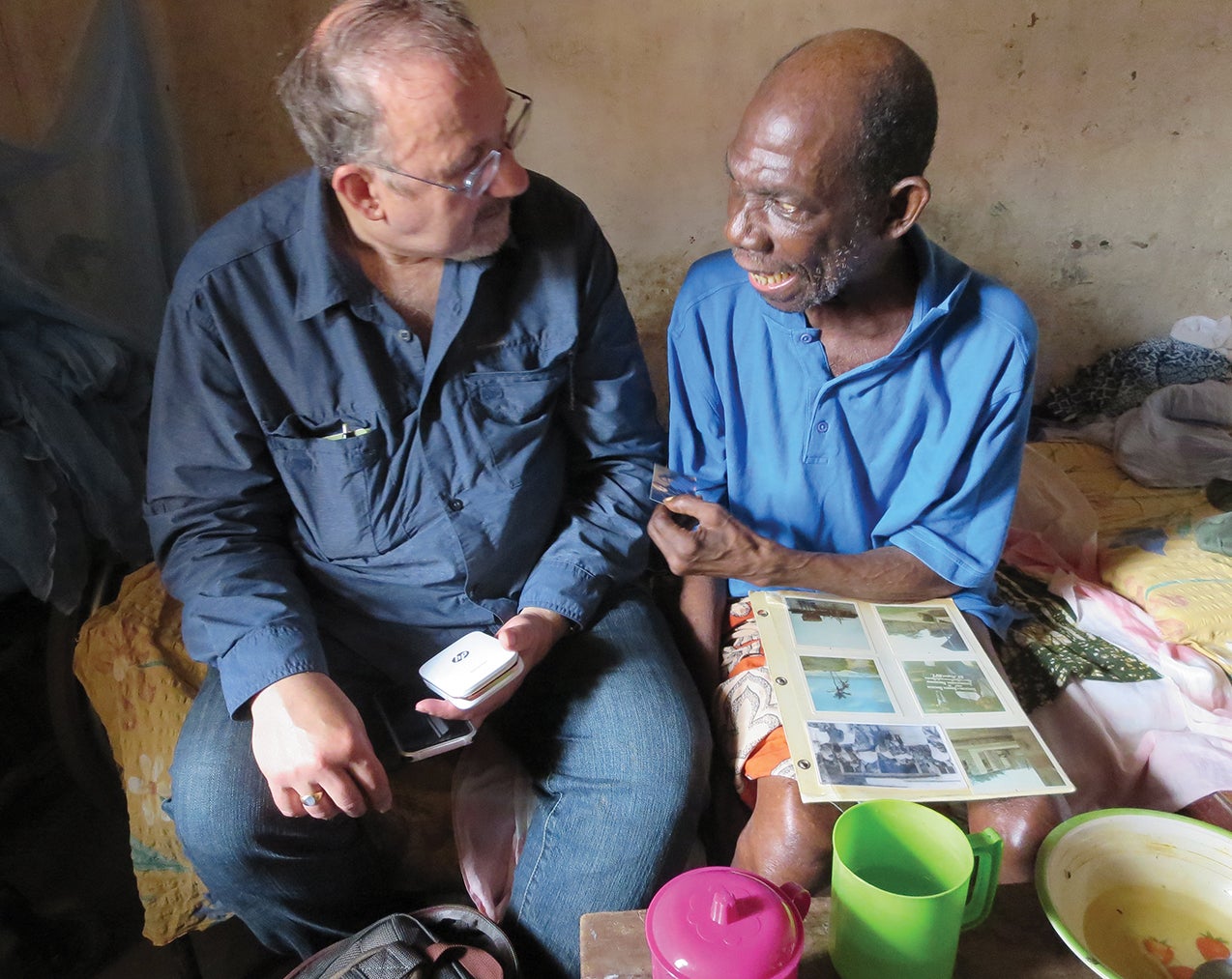 Paul Ventura looks at a photo album with an old friend.