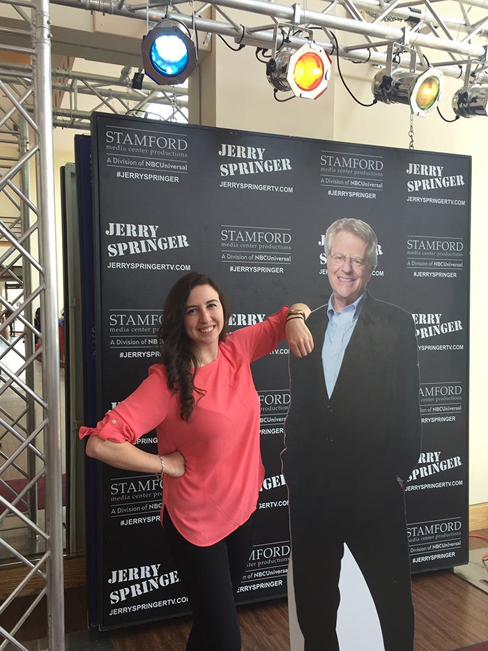 Klein poses with a cardboard Jerry Springer in front of a black background