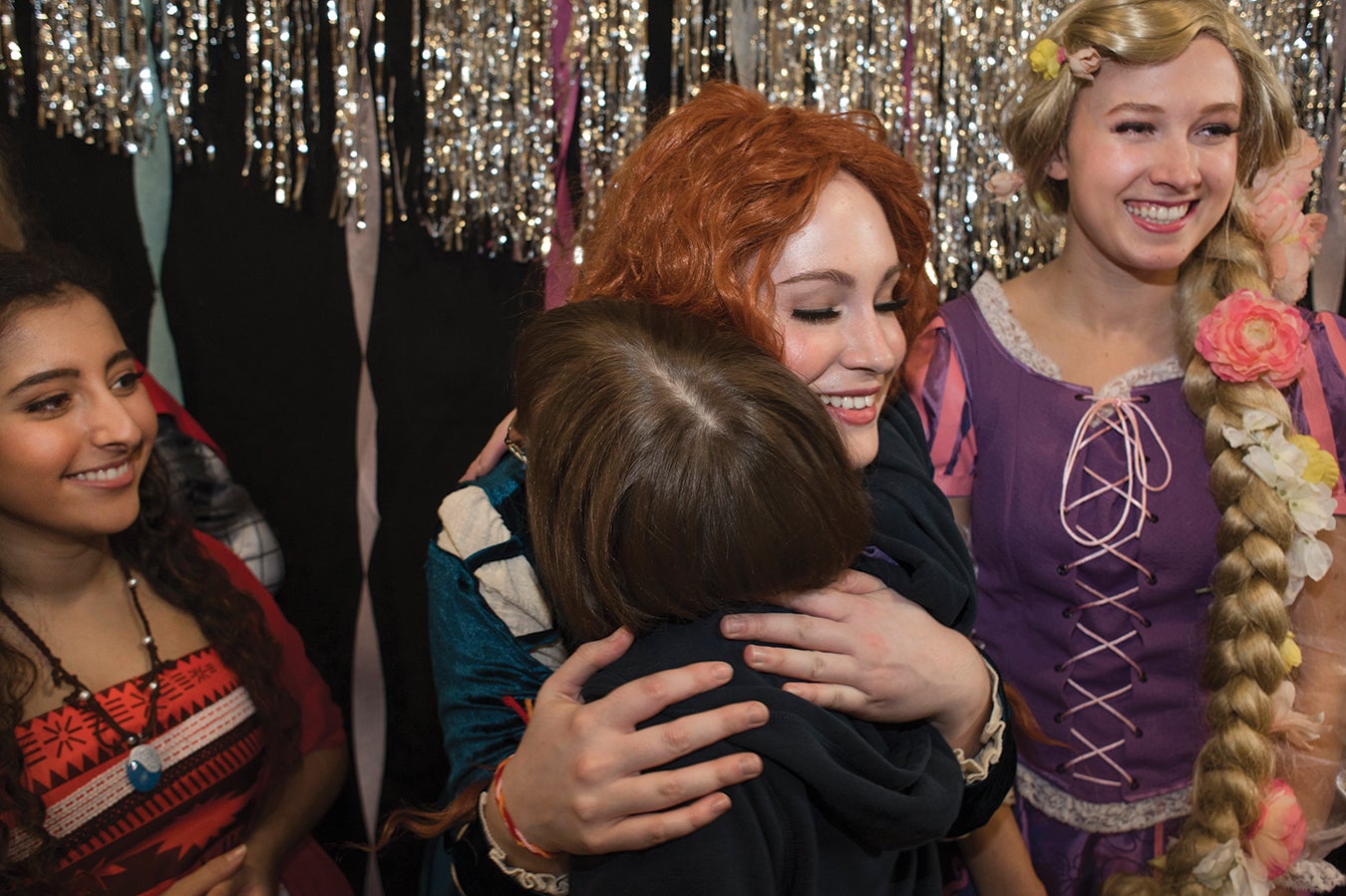 TIP princesses take turns giving farewell hugs. From left to right: Argirel Lion, TIP board member and communication and English nonfiction writing major; Gabrielle Gieringer, natural sciences major; and Daniela Krahe.