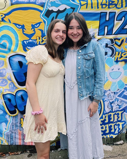 Zaslow and Rosen in front of a blue and yellow background