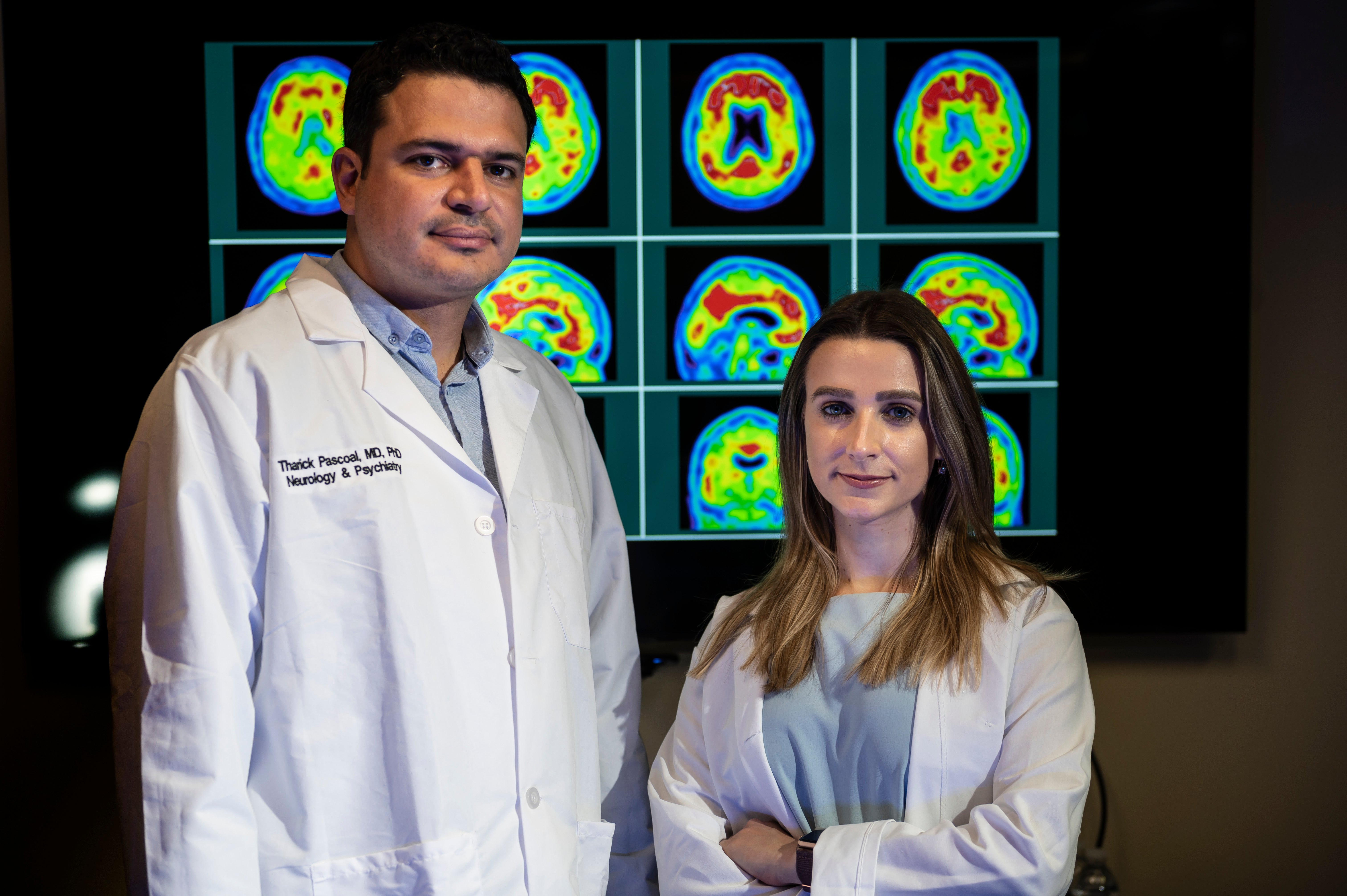 two people in front of brain scans