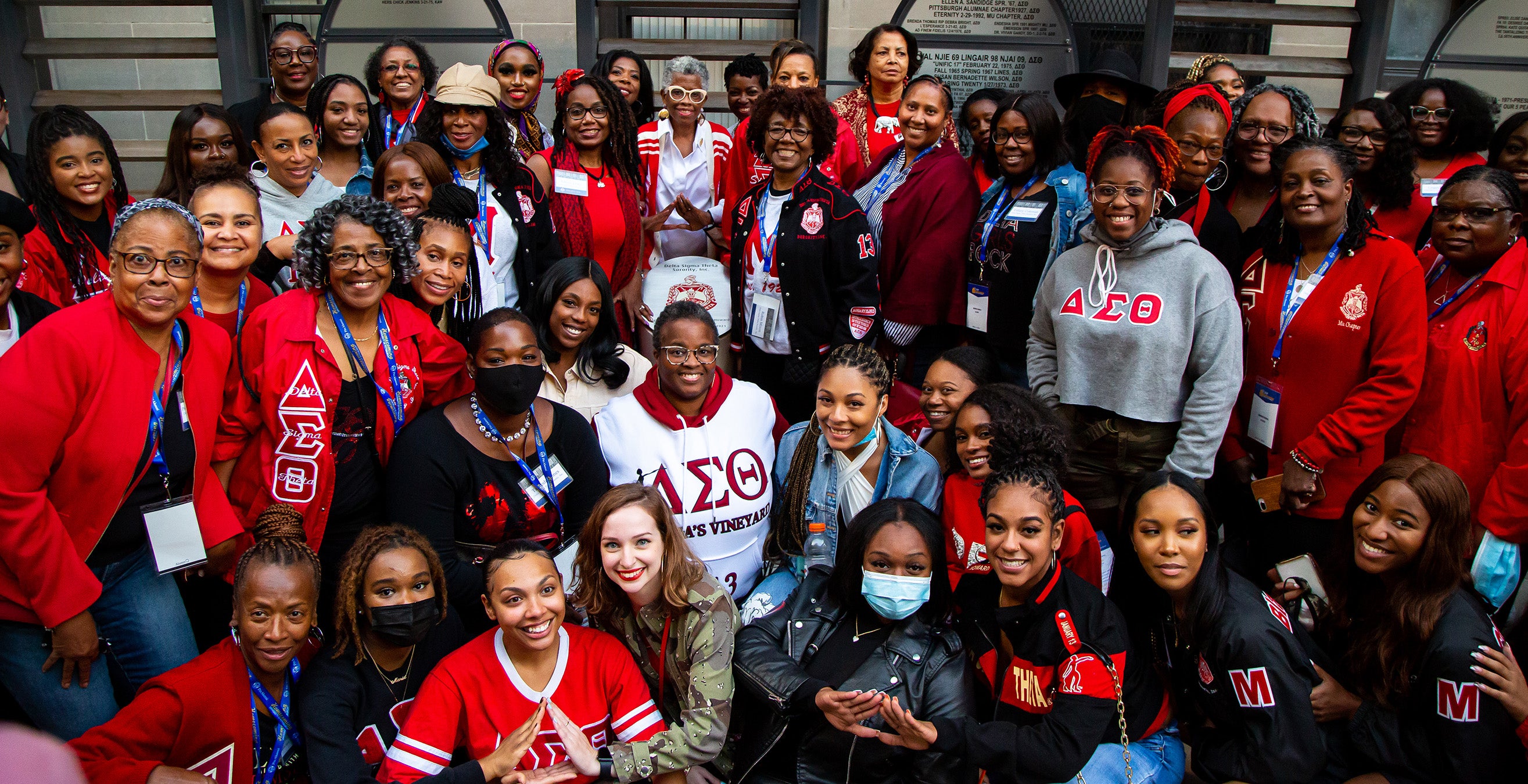 Members of Delta Sigma Theta pose wearing red clothing displaying Greek letters