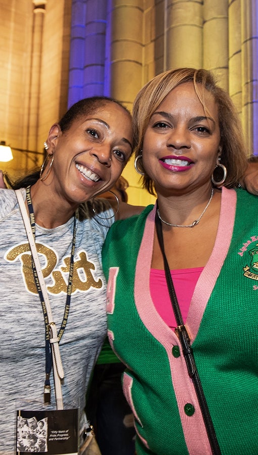 Tracy Floyd (left) and Carla Jackson meet up in the Cathedral of Learning during Homecoming week.