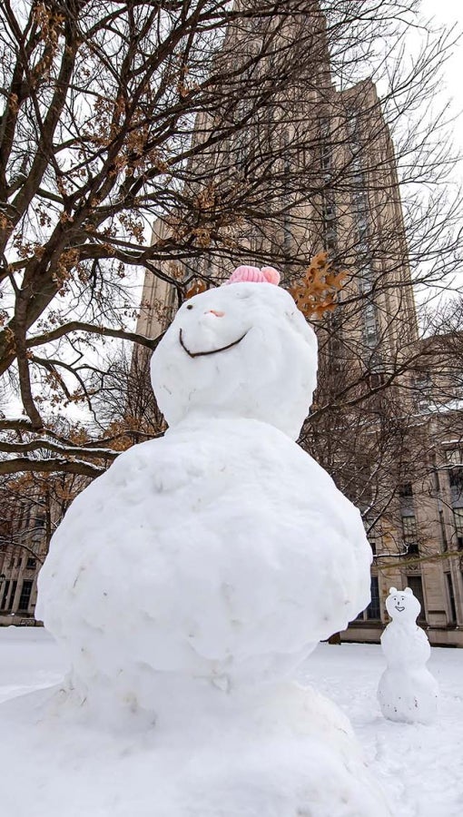 Two snowpeople in the Cathedral of Learning lawn