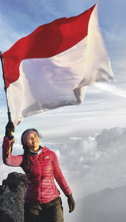 Diansyah Putri Handayani waves the Indonesian flag on the top of Mount Kerinci