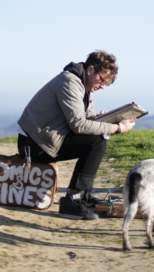 Daniel McCloskey sitting and reading; dog beside him