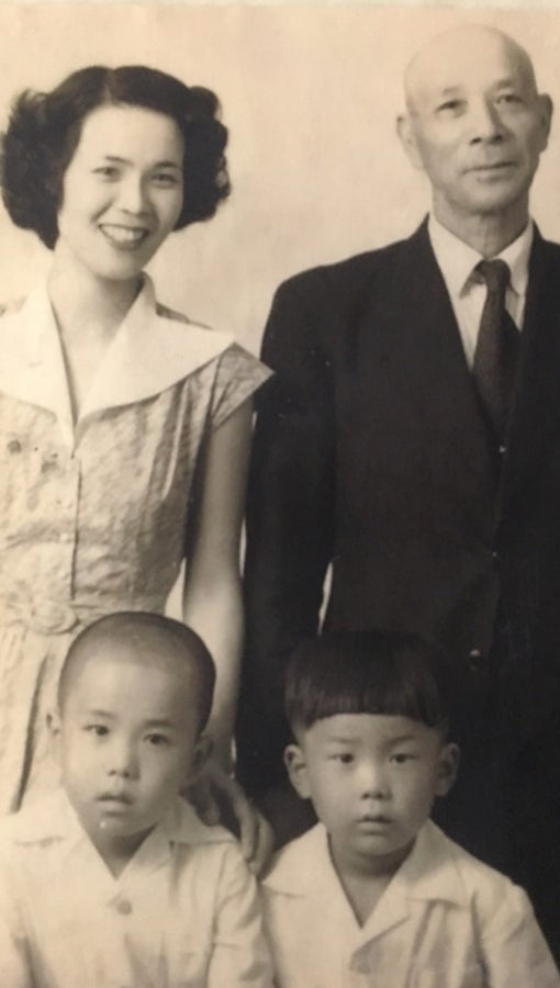 An archival photo of Yamatani and his brother as young boys with their mother and father.