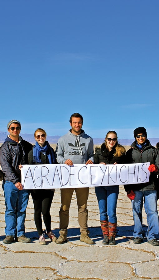 Kevin Rieth, far left, and peers hold sign that reads "Thank you" in Quechua while visiting the Salar de Uyuni in Bolivia.