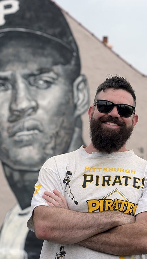 Jeremy M. Rayber stands in front of his mural of Pittsburgh Pirates Hall-of-Famer Roberto Clemente