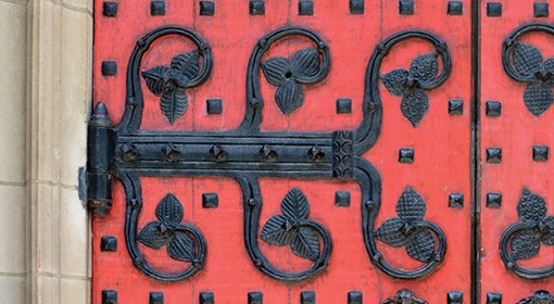 Red wooden door with wrought iron detailing at Heinz Memorial Chapel