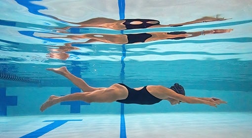 A person swims in a pool underwater
