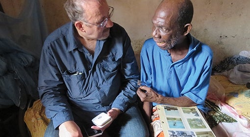 Ventura, left, with an old friend looking at a photo album