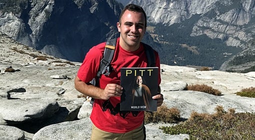 Scott Szypulski on top of Half Dome in Yosemite National Park, holding the Summer 2018 issue of Pitt Magazine